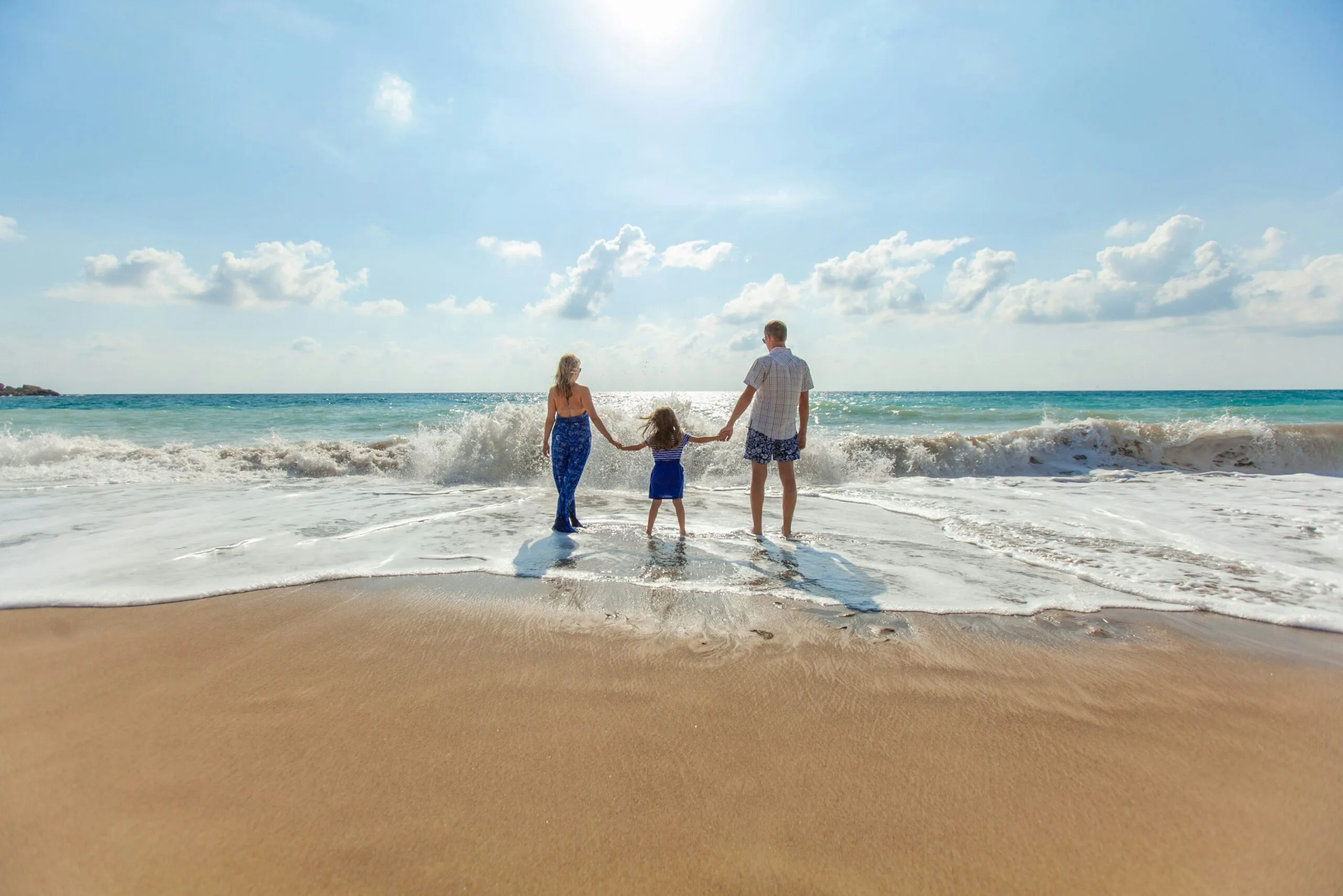 The Ultimate Guide to Family-Friendly Travel: Planning the Perfect Trip with Kids 1 man, woman and child holding hands on seashore