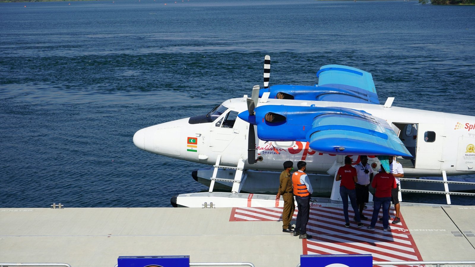 people walking on the dock near white and blue airplane during daytime